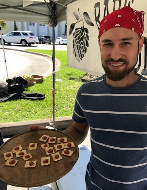 Credit: Gretchen Schmidt, Edible South Florida Jorge Zaldivar of PG Tropicals serving Redland guava tastes at the Coral Gables farmers market
