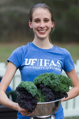 Credit: UF/IFAS Woman wearing UF/IFAS shirt and holding freshly harvested kale